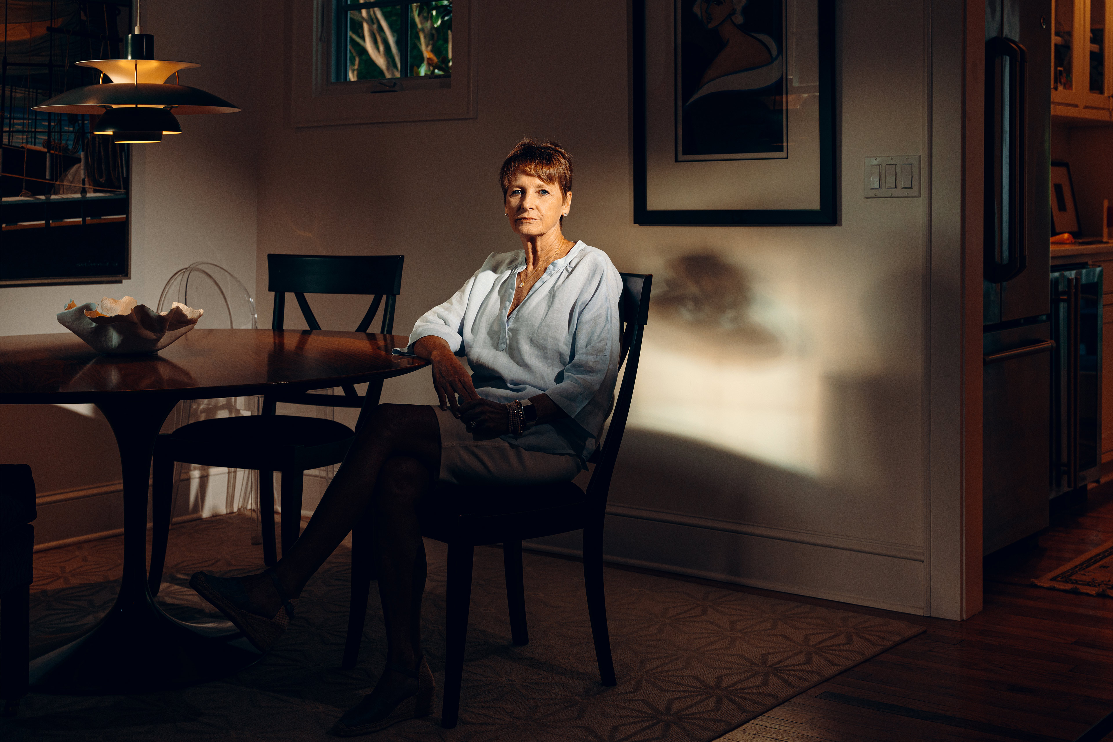 A photo of a woman sitting in her dining room.