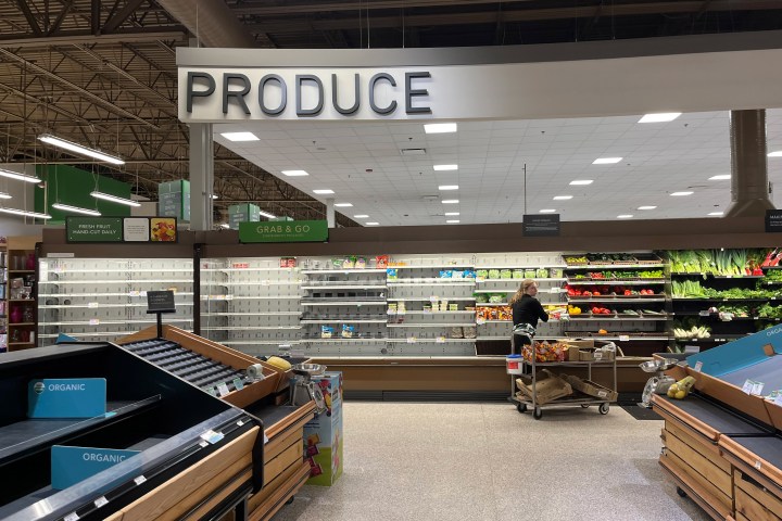 A photo of a produce section in a grocery store with several cleared shelves.