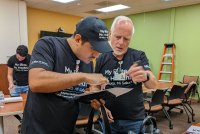 A photo shows Jonathan Flores and Robert Blackmon looking at a tablet.