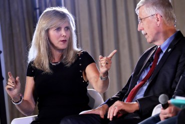 A photo of Laura Esserman pointing to another speaker onstage at a conference.