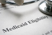 A photo of a piece of paper that reads, "Medicaid Eligibility" with a stethoscope on top.