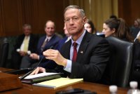 A photo of former Governor Martin O'Malley seated and moving a microphone while testifying before the Senate Finance Committee.