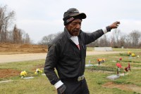 A photo shows Johnnie Haire standing for a portrait at a cemetery.