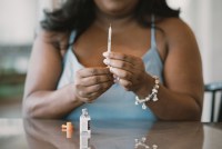 Mila Clarke holds a syringe of insulin in front of her.