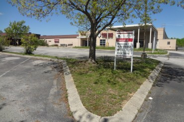 A photograph of a closed hospital taken from the parking lot.