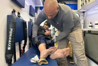 A photo of medical professional treating a wound on a homeless patient.