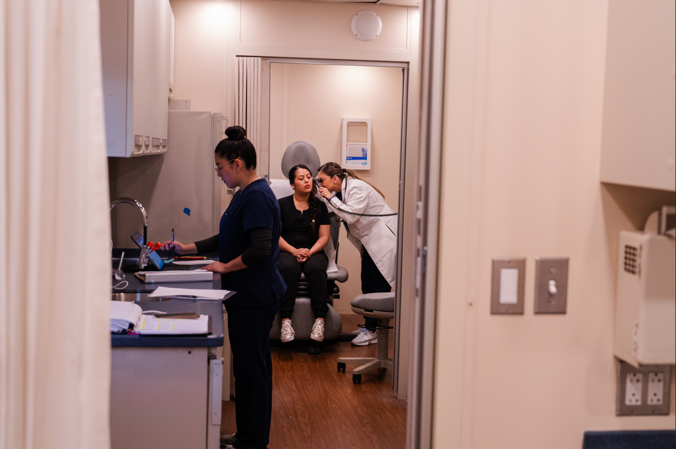 Several nurses in scrubs work in a mobile health clinic